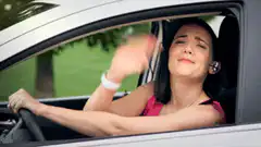 woman in car rolls up window