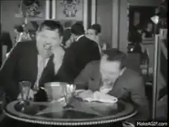 Two men laughing hysterically at a table
