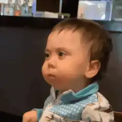 Baby with puffed cheeks looking skeptical