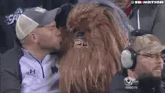 Man kisses Chewbacca at football game