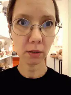 Woman with wide eyes and hand on chin