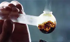 Hand holding smoking glass pipe