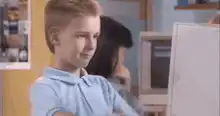 Boy gives thumbs up to computer