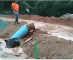 Construction worker emerges from pipe