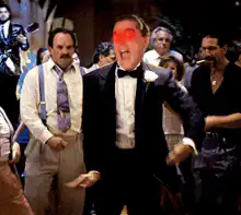 Man in tuxedo dancing with glowing red eyes
