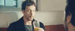 Man sipping orange juice with straw