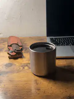 metal cup on wooden desk