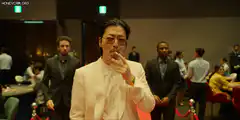 Man in white suit smokes cigarette