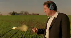 Man with ear protection holding a sparkler in a field