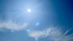 bright sun in blue sky with lens flare