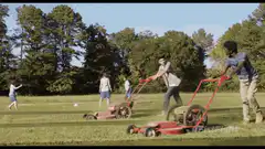Two men mow lawns into a giant lawnmower shape