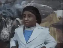 Young boy in white suit looking confused