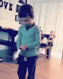 Boy laughs while holding a white object