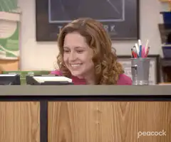 Pam Beesly smiling at desk