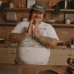 Man in kitchen clapping hands
