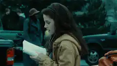 Kristen Stewart reading a paper and smiling