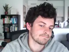 man smirking in grey hoodie