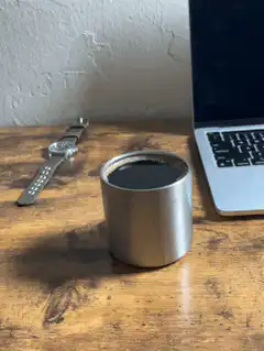 Coffee cup on desk next to laptop