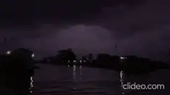 Stormy night with lightning over water and palm trees