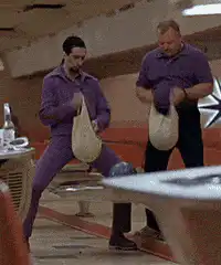 Two men in purple suits holding bags