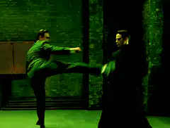 Agent Smith dodging kicks in green hallway