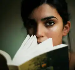 woman peeking over book