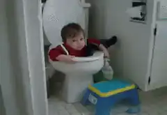Baby sitting in toilet bowl