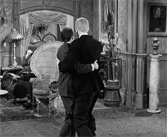Two men dancing in a parlor