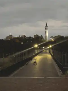 Bridge at night with a lighthouse