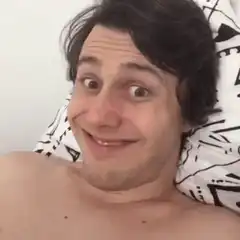 man lying in bed smiling