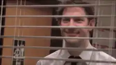 Jim Halpert smirking through blinds