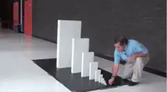 Man knocks over dominoes