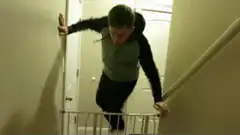 Man falls over baby gate on stairs
