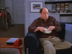Jerry Seinfeld eating cereal on the couch
