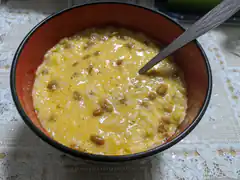 Bowl of yellow rice porridge with beans