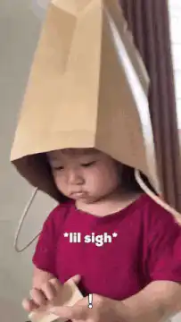 Toddler with paper bag on head sighing