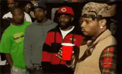 Usher holding a red cup and looking around