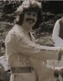 Man in white suit smiling