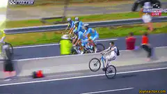 Man on bike rides alongside pro cyclists