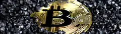 Gold Bitcoin on black gravel