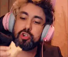 Man eating spring roll with pink headphones