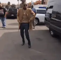Snoop Dogg dancing in a tan coat