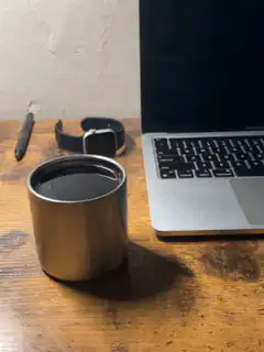 Coffee cup on desk next to laptop
