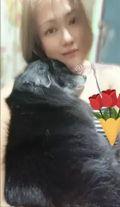 woman holding black cat with tulips