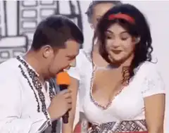 Man sings into microphone near woman