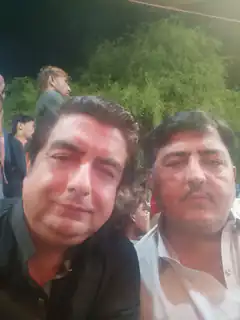 Two men posing for a selfie at night