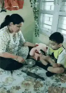 Mother feeds boy and teddy bear