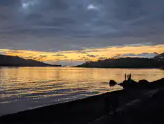 sunset over water with silhouettes