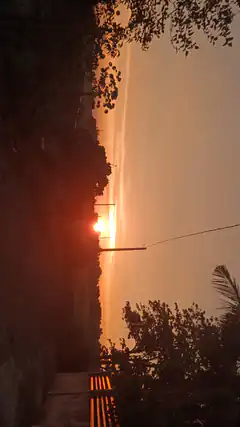 sunset over water with trees and dock