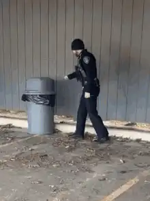 Police officer pees in trash can